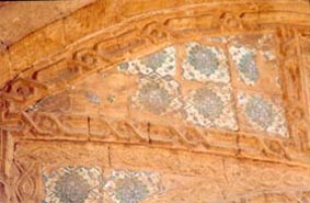 Missing colored ornamental ceramic tiles.Deteriorated stone profile. 